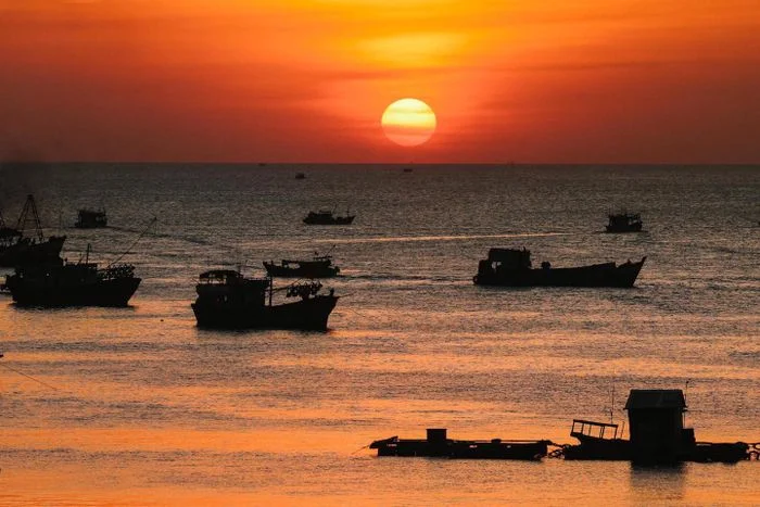 Những chiếc thuyền nhỏ trên biển dưới ánh hoàng hôn