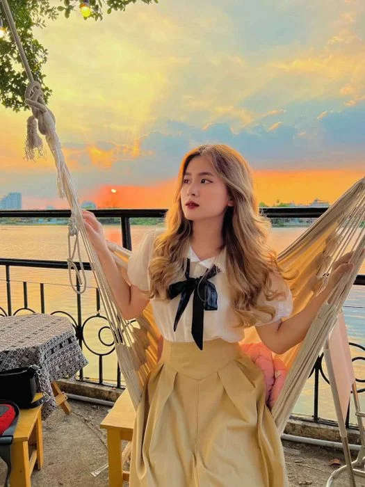 Cô gái ngồi thư giãn trong ánh hoàng hôn nhẹ nhàng