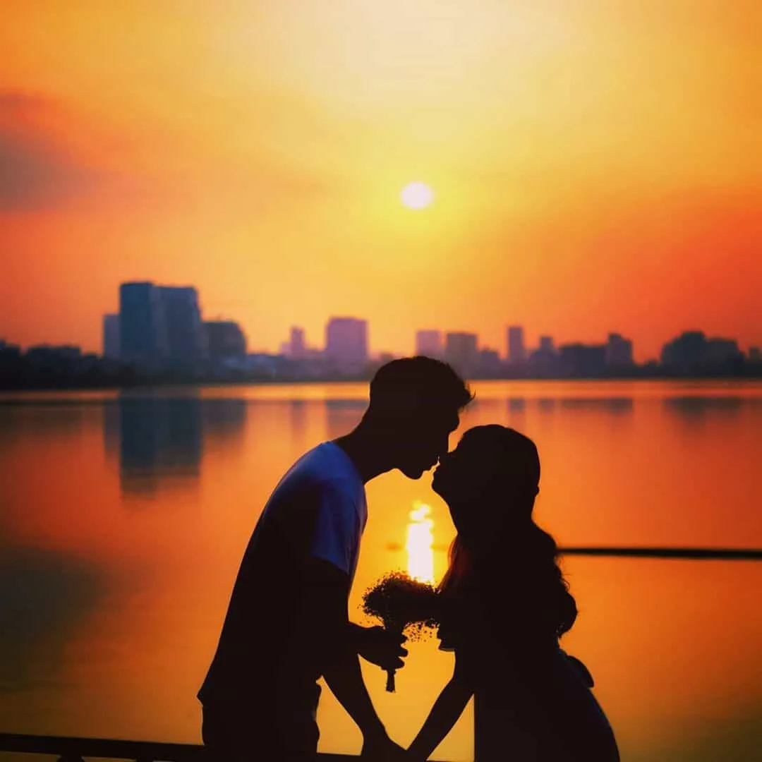 Cặp đôi nắm tay nhau ngắm cảnh hoàng hôn chill bên hồ