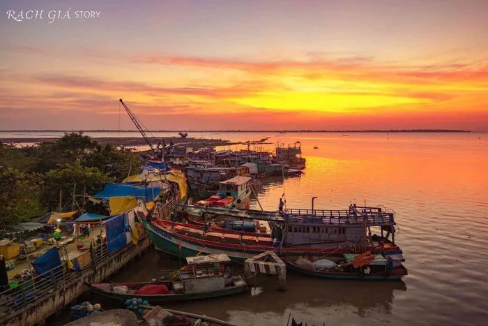 Cảnh ảnh hoàng hôn chill với những con thuyền đánh cá bên bờ sông rực rỡ ánh cam