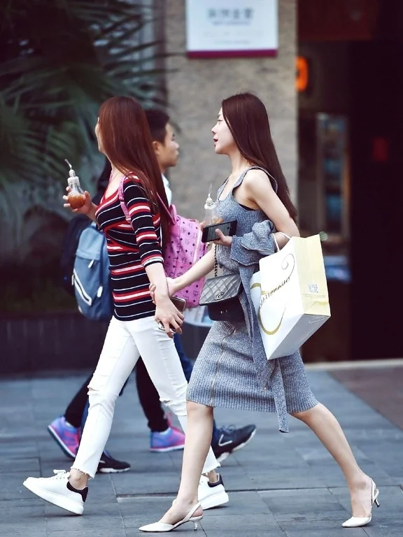 Hai cô gái xinh cute đang đi dạo trên phố với trang phục thời trang hiện đại