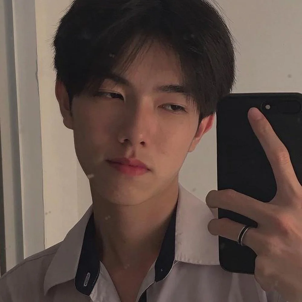 Ảnh trai đẹp Việt Nam chụp selfie trước gương, tóc đen ngắn, mặc áo sơ mi trắng viền đen, tông màu phim trầm ấm