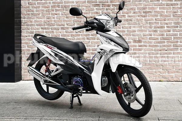 Xe máy thể thao màu trắng đỗ trước tường gạch