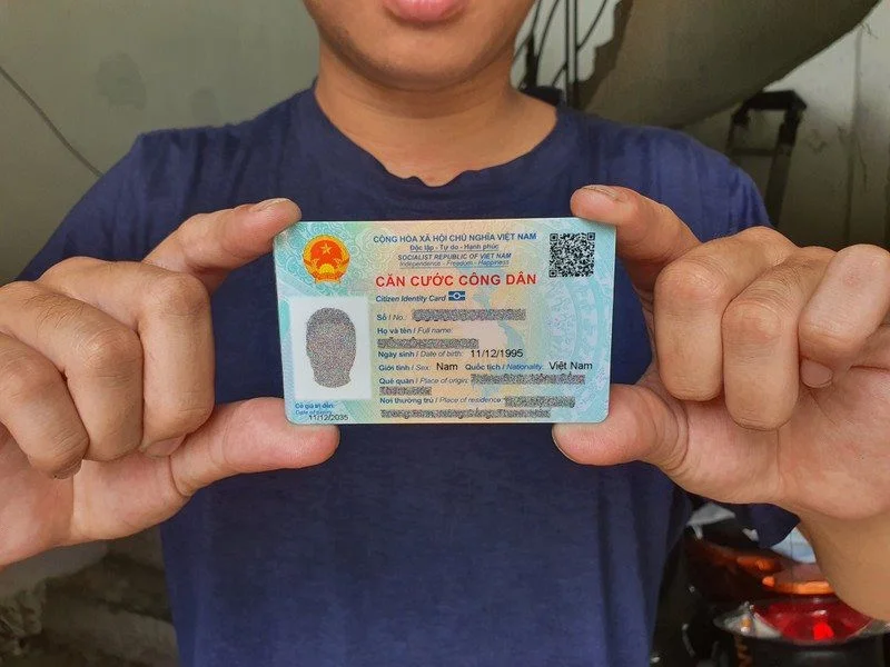 Người đàn ông cầm thẻ Căn cước công dân (CCCD) thật trên tay.